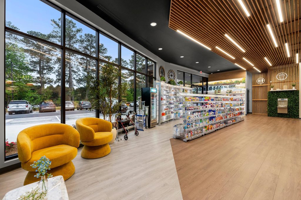 Retail area of The Pharmacy Place with large windows, yellow lounge chairs and custom wood furnishings.