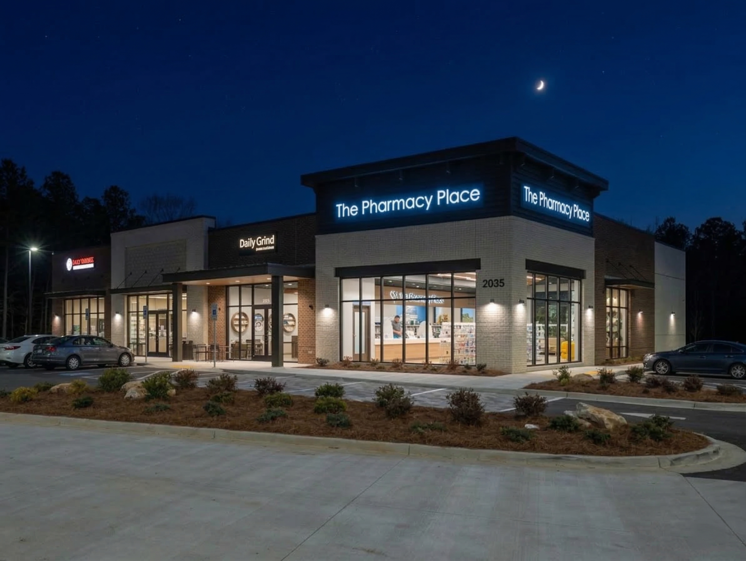 Nighttime exterior facade of a modern pharmacy with illuminated signage.